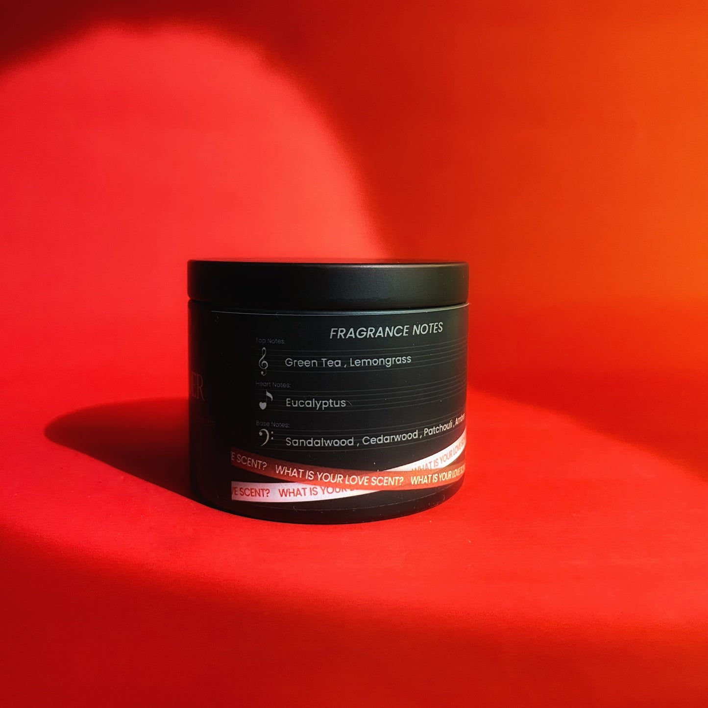 Black container with fragrance notes on a red background