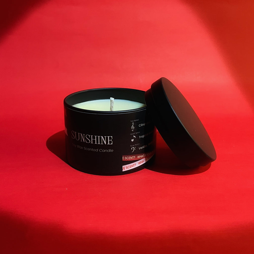 Candle in a black container labeled 'Sunshine' on a red background